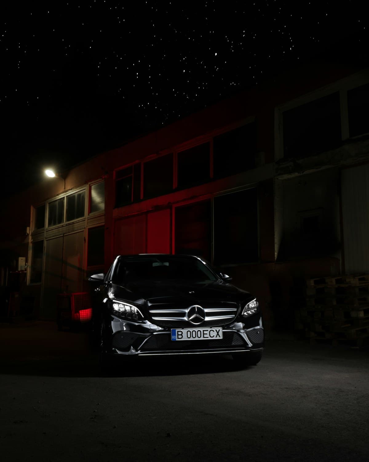 Черен Mercedes-Benz пред осветена сграда